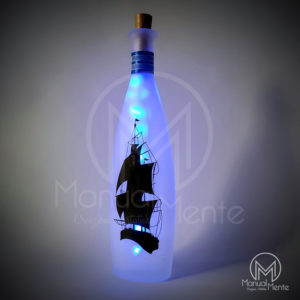 Lanterna in bottiglia con veliero, onde in rilievo e via lattea nella notte.